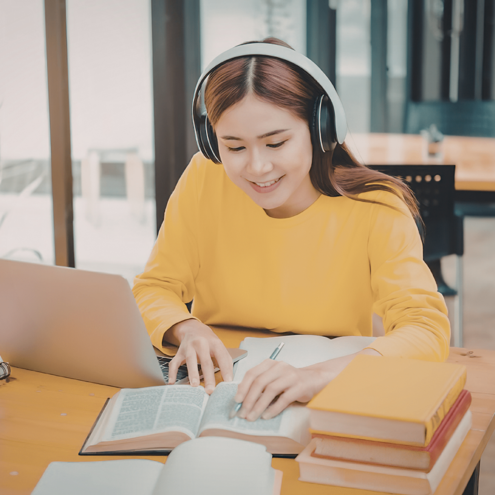 Educator studying at home with laptop and textbook
