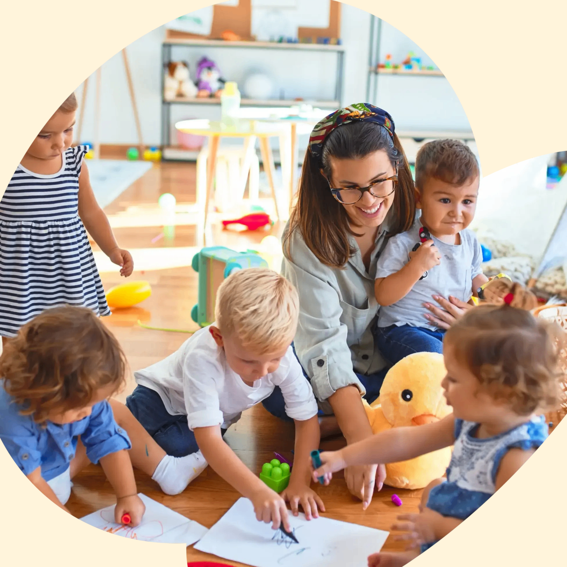 Educator with a smiling toddler in a bright daycare classroom