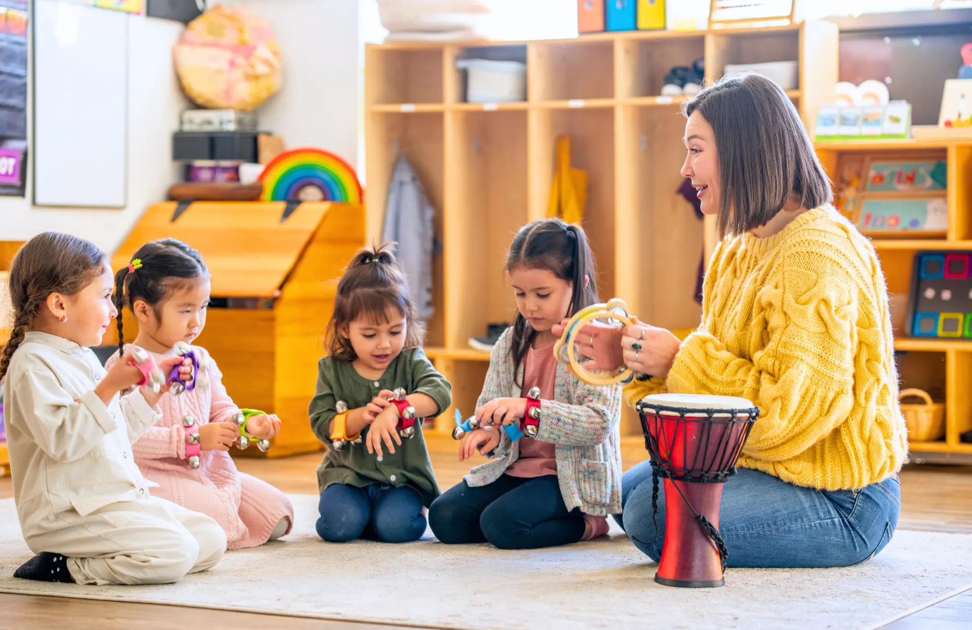 Early childhood educator playing musical instruments with a group of young children