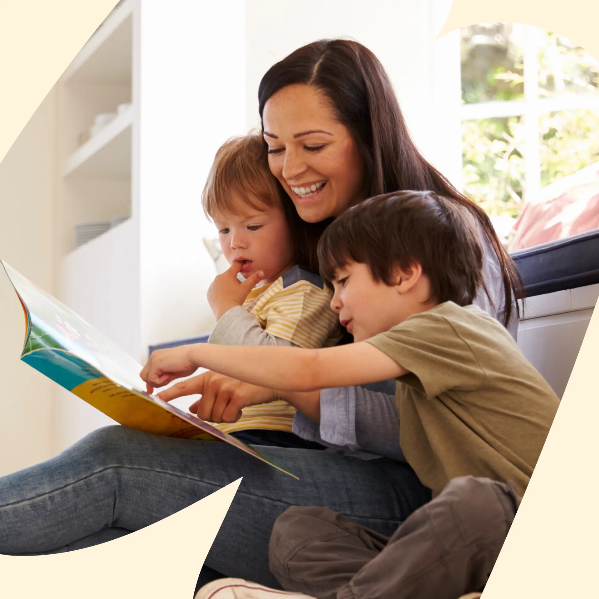 Childcare professional playing with a smiling toddler in a bright home living room