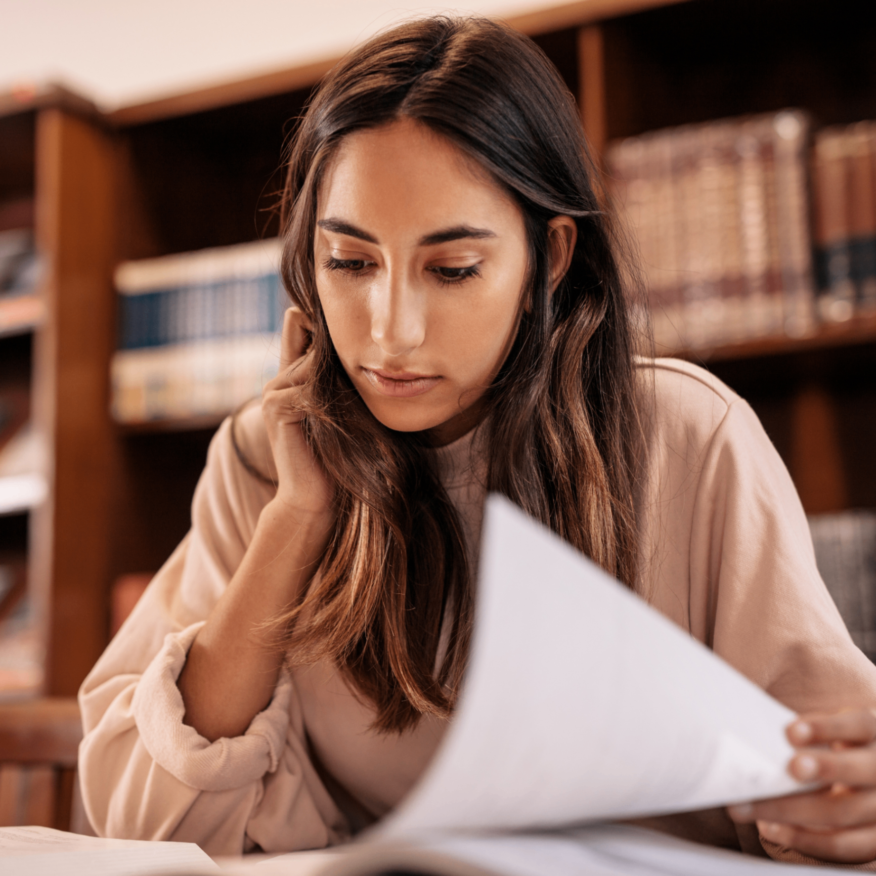 Educator studying at home with laptop and textbook