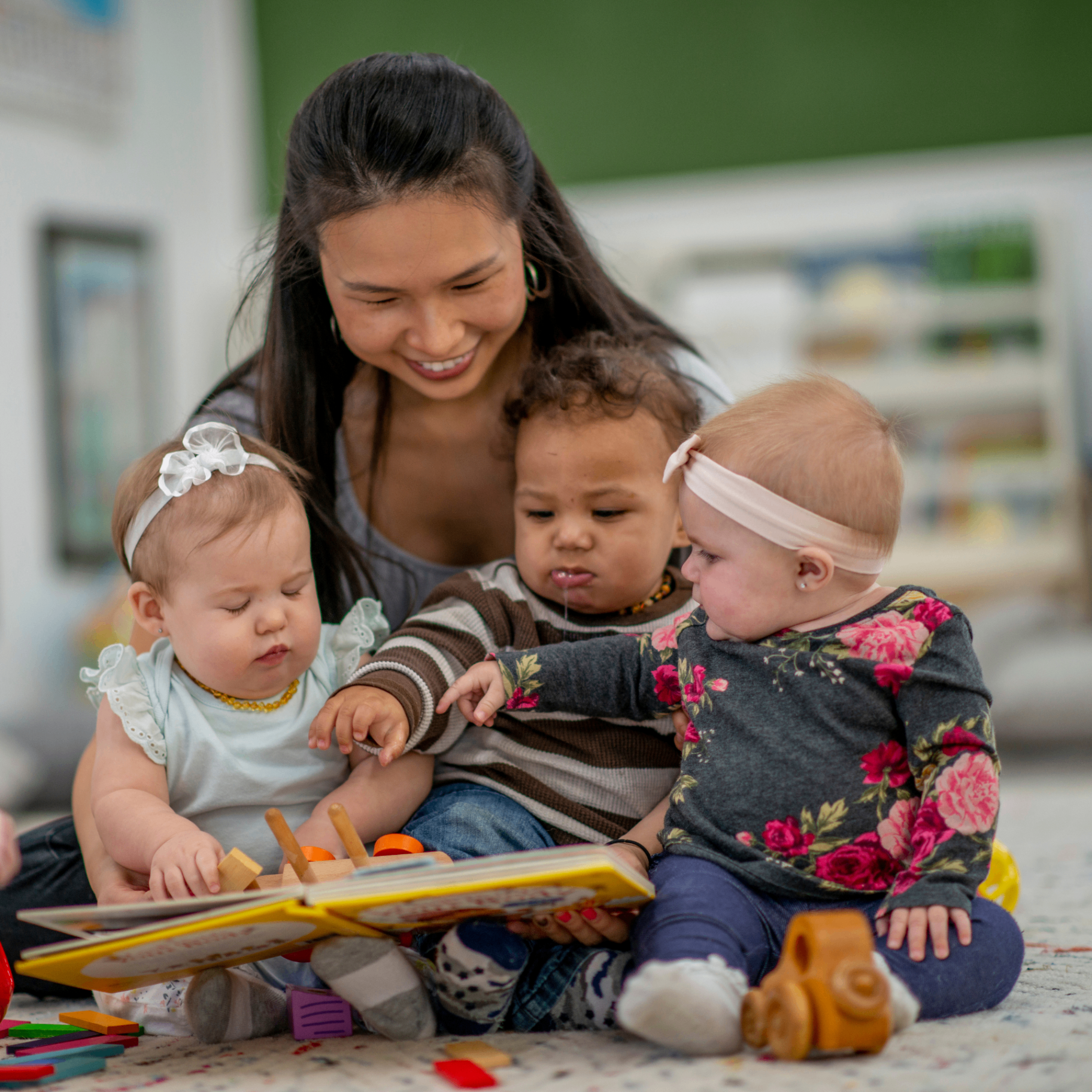 Educator playing with a toddler in a bright childcare centre